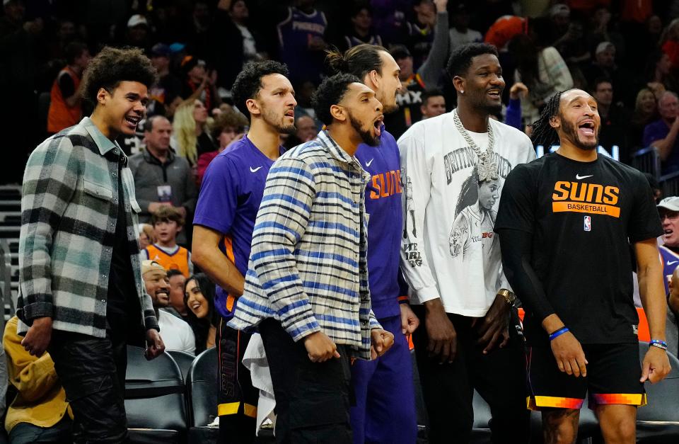 December 17, 2022; Phoenix, Ariz; USA; Suns Cameron Johnson (L), Landry Shamet, Cam Payne, Dario Saric, Deandre Ayton, and Ish Wainwright react after a Booker basket against the Pelicans during the second half at the Footprint Center. 