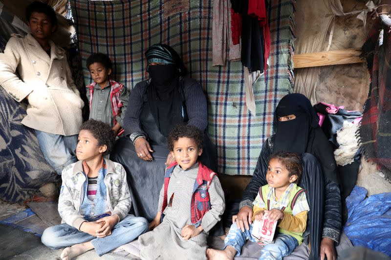 Sameera Hussein Nasser, 40, sits with her children at a hut where they live at a camp for internally displaced people near Sanaa