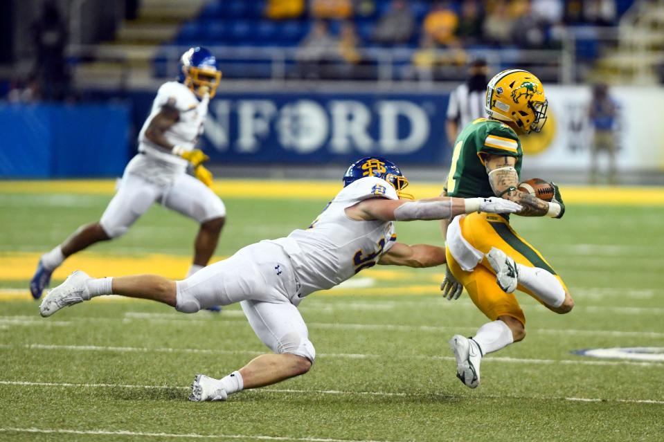 South Dakota State's Adam Bock tackles North Dakota State's Christian Watson during the Dakota Marker rivalry game on Saturday, April 17, 2021, at the Fargodome in Fargo. 