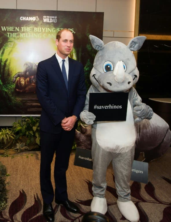 Britain's Prince William, Duke of Cambridge poses with an activist dressed as a white rhinoceros after delivering a speech at the Hanoi conference on illegal wildlife trade being held in Hanoi on November 17, 2016