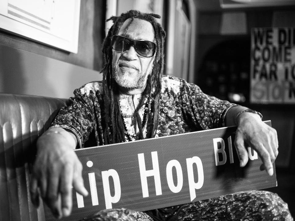 DJ Kool Herc poses with a sign that says Hip Hop Blvd for a picture at The Source awards