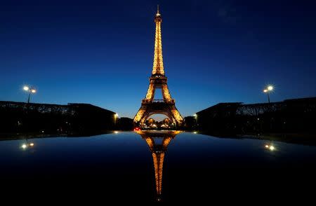 A night view shows the Eiffel tower, reflected in a car's roof, in Paris, France, April 30, 2016. REUTERS/Christian Hartmann