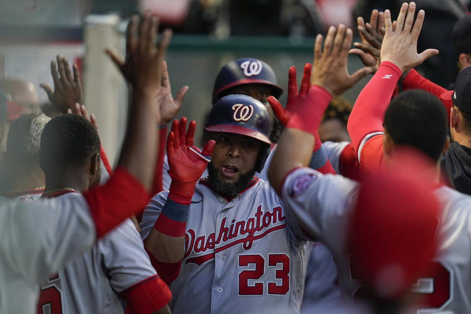 Washington Nationals designated hitter Nelson Cruz (23) high-fives teammates in the dugout after hitting a home run during the fifth inning of a baseball game against the Los Angeles Angels in Anaheim, Calif., Saturday, May 7, 2022. Josh Bell also scored. (AP Photo/Ashley Landis)