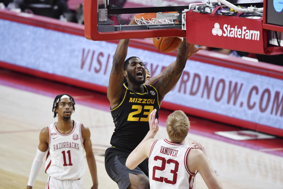 Missouri forward Jeremiah Tilmon (23) dunks the ball over Arkansas defenders Jalen Tate (11) and Connor Vanover (23) during the first half of an NCAA college basketball game in Fayetteville, Ark. Saturday, Jan. 2, 2021. (AP Photo/Michael Woods)