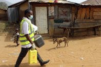 Yunusa Bawa, a community health worker, carries a box of AstraZeneca coronavirus vaccine, in Sabon Kuje on the outskirts of Abuja, Nigeria, Monday, Dec 6, 2021. As Nigeria tries to meet an ambitious goal of fully vaccinating 55 million of its 206 million people in the next two months, health care workers in some parts of the country risk their lives to reach the rural population. (AP Photo/Gbemiga Olamikan)