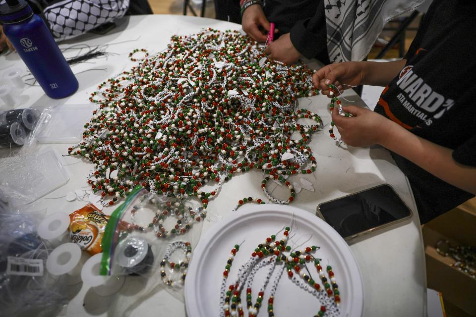 A heap of bracelets are almost finished, just needing to be tied together, for former Girl Scout Troop 149's fundraiser for children affected by the violence in Gaza at the Dar Al Jalal Masjid Mosque in Hazelwood, Mo. on Saturday, March 2, 2024. The troop's goal is to make 2000. (Vanessa Abbitt/St. Louis Post-Dispatch via AP)