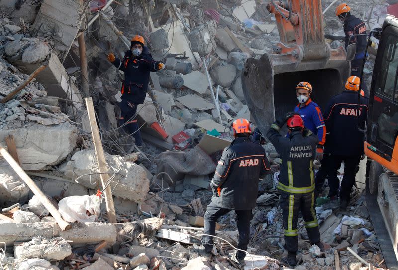 Emergency personnel work at the site of a collapsed building, after an earthquake in Elazig
