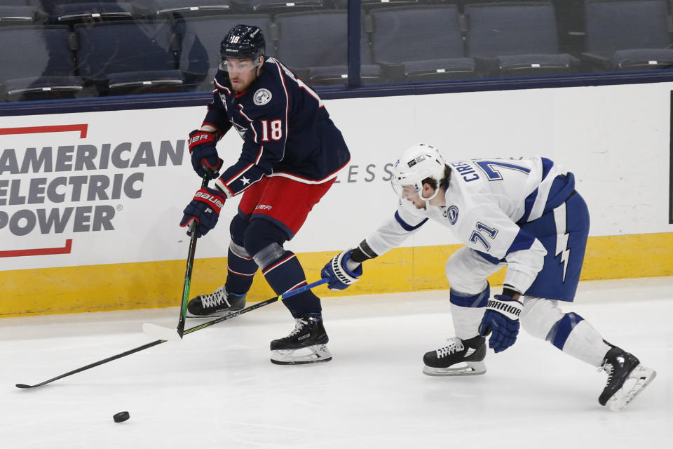 Columbus Blue Jackets' Pierre-Luc Dubois, left, carries the puck up ice against Tampa Bay Lightning's Anthony Cirelli during the first period of an NHL hockey game Thursday, Jan. 21, 2021, in Columbus, Ohio. (AP Photo/Jay LaPrete)