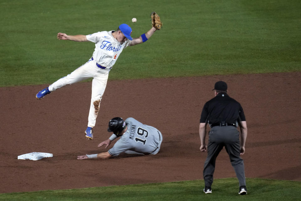 South Carolina's Cole Messina (19) steals second base as the throw goes over Florida's Cade Kurland during the fifth inning of an NCAA college baseball tournament super regional game Friday, June 9, 2023, in Gainesville, Fla. (AP Photo/John Raoux)