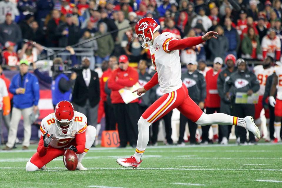 Harrison Butker kicking the football at the Chiefs vs Patriots game