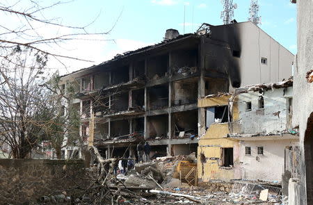 Police forensic experts examine a destroyed police station in Cinar in the southeastern city of Diyarbakir, Turkey, January 14, 2016. REUTERS/Sertac Kayar