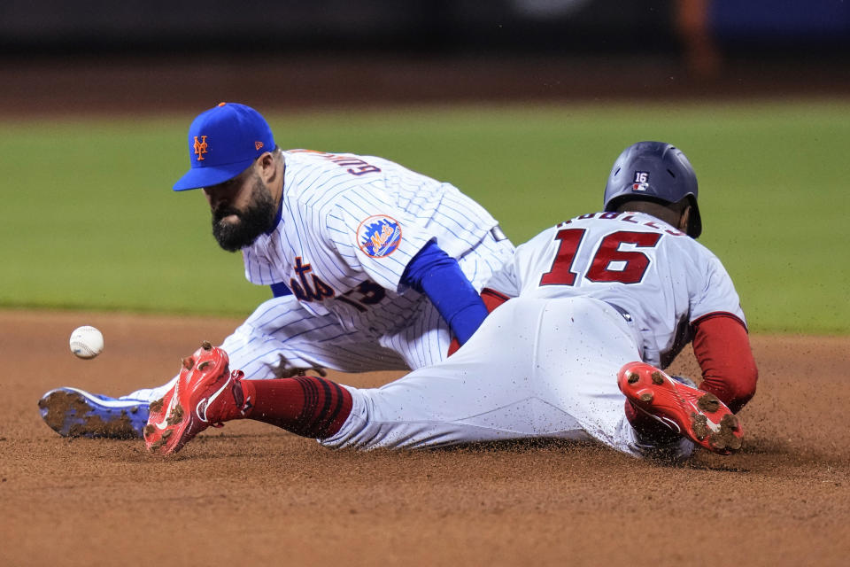 New York Mets Luis Guillorme loses control of the ball, allowing Washington Nationals' Victor Robles (16) to steal second base during the seventh inning of a baseball game Tuesday, April 25, 2023, in New York. (AP Photo/Frank Franklin II)