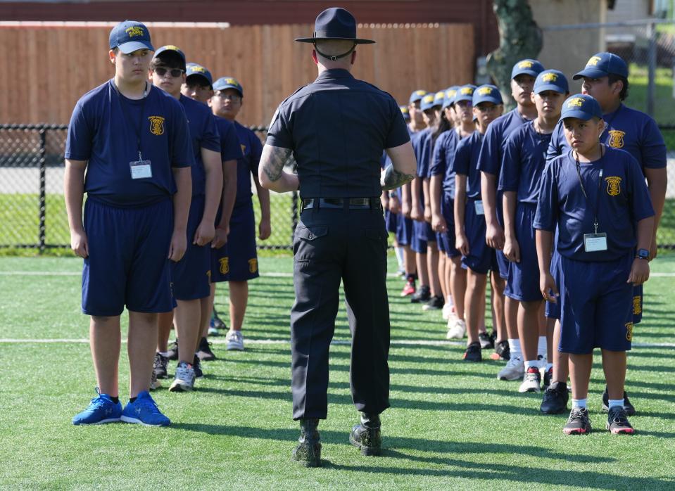 Dover, NJ August 1, 2023 -- Morris County Police Academy Drill Instructor, Washington Twp. Ptl. Frank Giaquinto worked with members of the Dover Junior Police Academy as they start their day of training. Over 30 kids assembled at the American Legion hall, then marched to nearby Crescent Field for training.