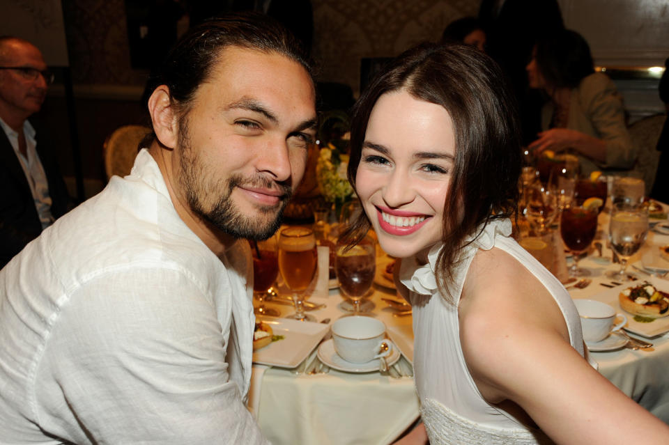 Jason and Emilia smile while sitting at a dinner table together