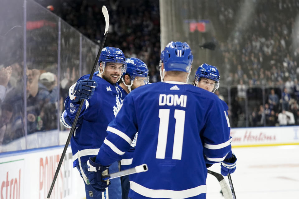 Toronto Maple Leafs center Auston Matthews (34) celebrates his third goal against the Philadelphia Flyers with Max Domi (11) during the second period of an NHL hockey game Thursday, Feb. 15, 2024, in Toronto. (Arlyn McAdorey/The Canadian Press via AP)