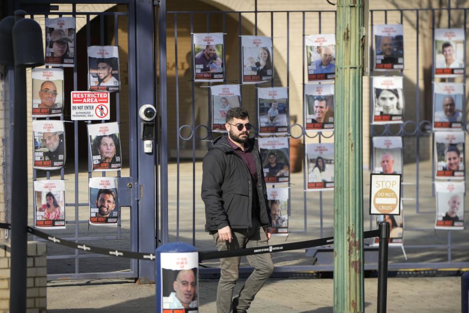 A man walks past the gates of the Israeli Embassy, Monday, Feb. 26, 2024, in Washington. An active-duty member of the U.S. Air Force has died after he set himself ablaze outside the Israeli Embassy in Washington, D.C., while declaring that he "will no longer be complicit in genocide." (AP Photo/Mark Schiefelbein)