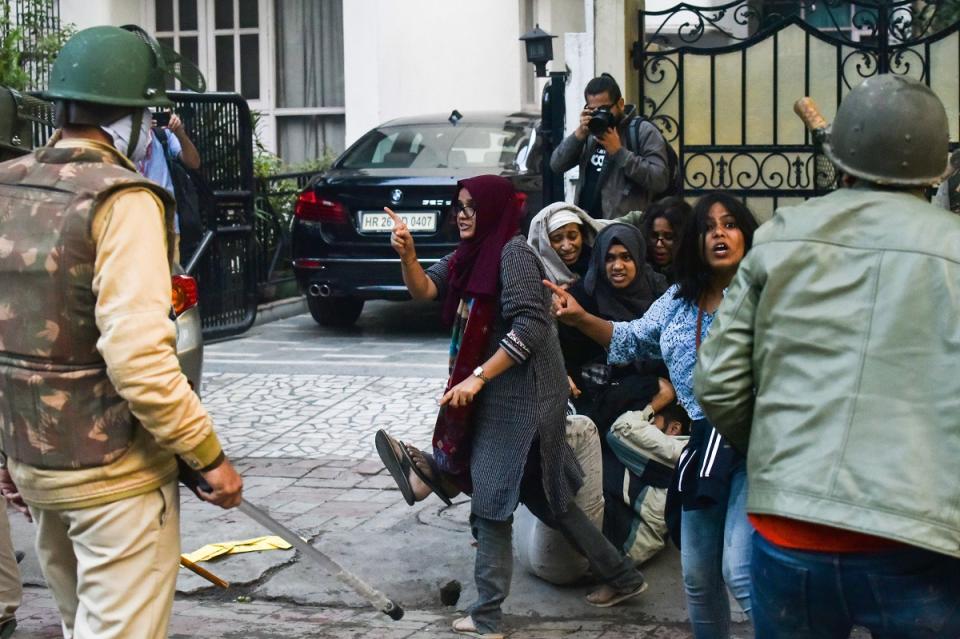 In this picture taken on December 15, 2019, Ayesha Renna (C) and other protesters argue with policemen during a demonstration against the Indian government's Citizenship Amendment Bill (CAB) in New Delhi. A group of Muslim woman who formed a human barricade around a male student being attacked by baton-swinging police are becoming icons in the protests currently gripping India. (Photo by STRINGER / AFP) / 