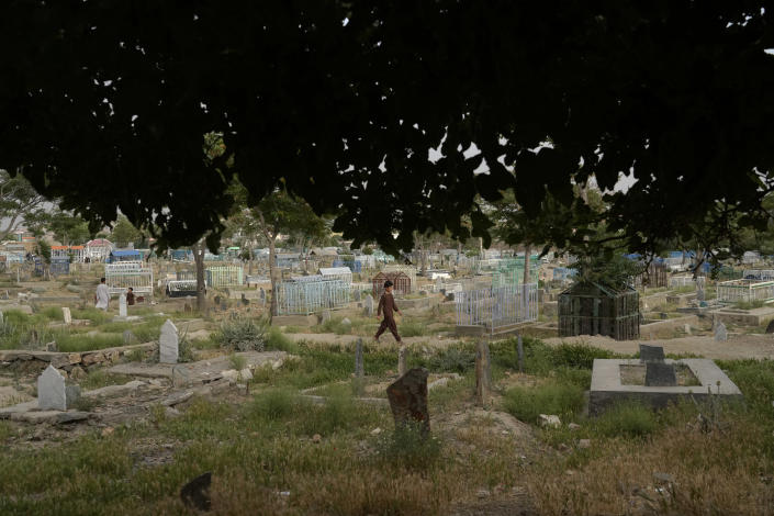 An Afghan boy walks among the graves at a cemetery in Kabul, Afghanistan, Sunday, May 15, 2022. There are cemeteries all over Afghanistan's capital, Kabul, many of them filled with the dead from the country's decades of war. They are incorporated casually into Afghans' lives. They provide open spaces where children play football or cricket or fly kites, where adults hang out, smoking, talking and joking, since there are few public parks. (AP Photo/Ebrahim Noroozi)