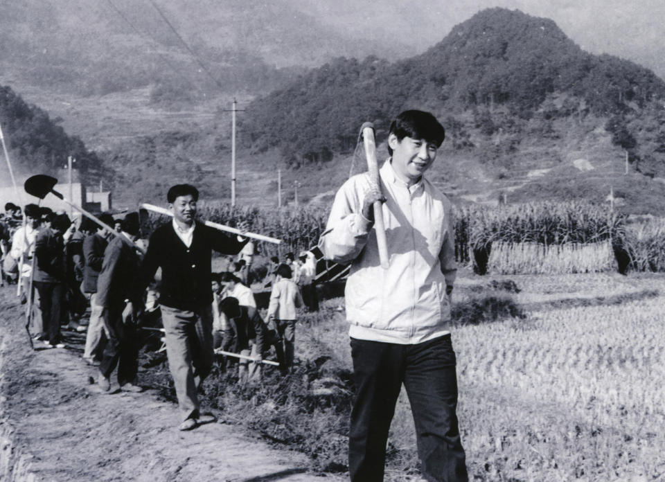 FILE - In this photo provided by China's Xinhua News Agency, Communist Party Leader Xi Jinping, right, then secretary of the Ningde Prefecture Committee of the Communist Party of China (CPC), participates in farm work during his investigation in the countryside in 1988. When Xi Jinping came to power in 2012, it wasn't clear what kind of leader he would be. His low-key persona during a steady rise through the ranks of the Communist Party gave no hint that he would evolve into one of modern China's most dominant leaders, or that he would put the economically and militarily ascendant country on a collision course with the U.S.-led international order. (Xinhua via AP, File)