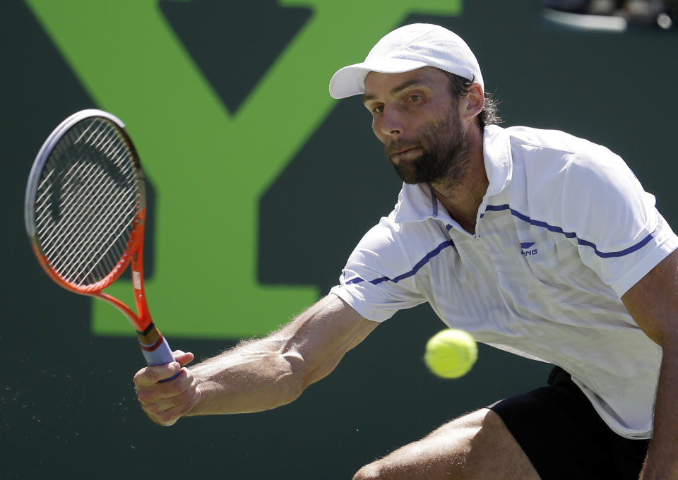 Ivo Karlovic, of Croatia, returns the ball to Roger Federer, of Switzerland, during a match at the Sony Open tennis tournament, Friday, March 21, 2014, in Key Biscayne, Fla. (AP Photo/Lynne Sladky)