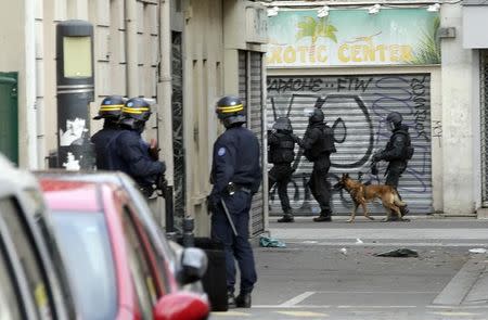 Members of special French RAID forces with a police dog and French riot police (CRS) secure the area during an operation in Saint-Denis, near Paris, France, November 18, 2015 to catch fugitives from Friday night's deadly attacks in the French capital. REUTERS/Philippe Wojazer