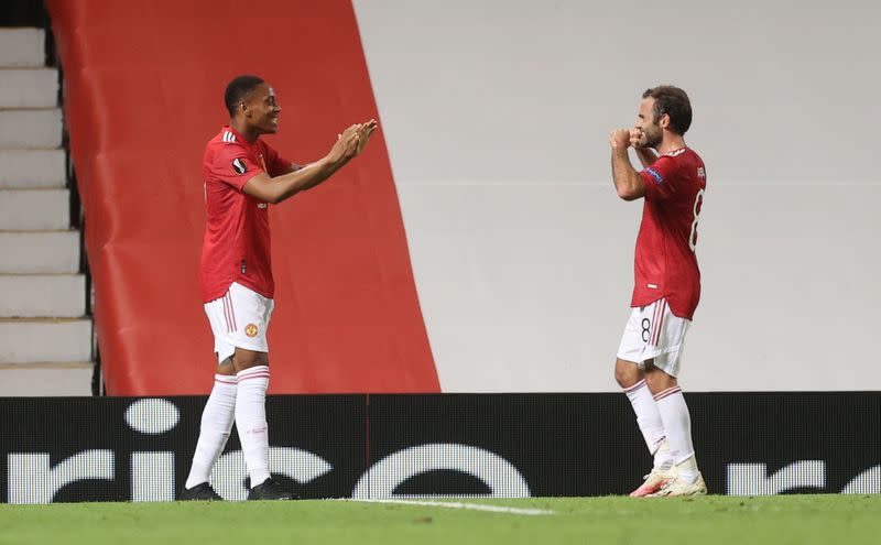 Anthony Martial celebra con Juan Mata un gol del Manchester United por los octavos de final de la Europa League ante el LASK Linz.