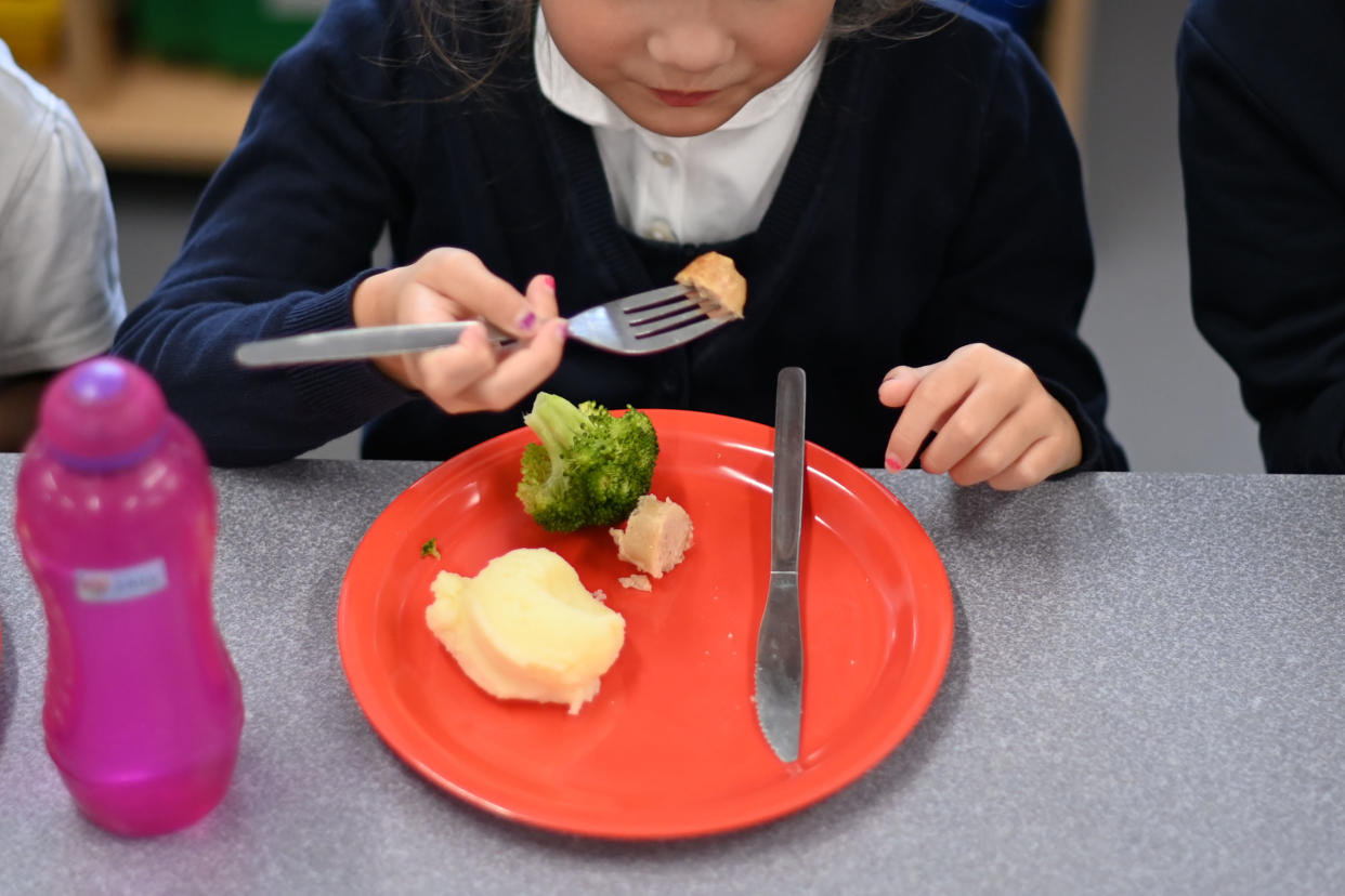 A pupil eats her cooked hot dinner during her lunch break in the canteen at St Luke's Church of England Primary School in East London on September 3, 2020. - Pupils in Britain have on Thursday begun to return to schools for the first time since they were all closed in March, due to the COVID-19 pandemic. (Photo by DANIEL LEAL-OLIVAS / AFP) (Photo by DANIEL LEAL-OLIVAS/AFP via Getty Images)