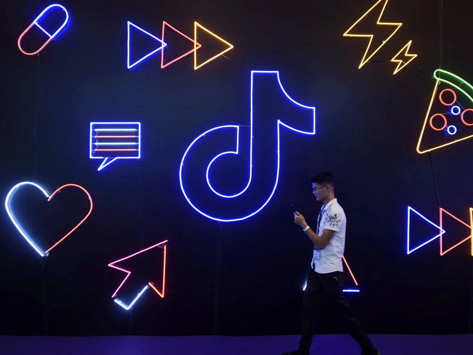 Man walks past a sign of ByteDance's app TikTok, known locally as Douyin, at an expo in Hangzhou