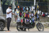 An Indian man checks a face mask before buying it in Hyderabad, India, Tuesday, Aug. 4, 2020. India is the third hardest-hit country by the pandemic in the world after the United States and Brazil. (AP Photo/Mahesh Kumar A.)