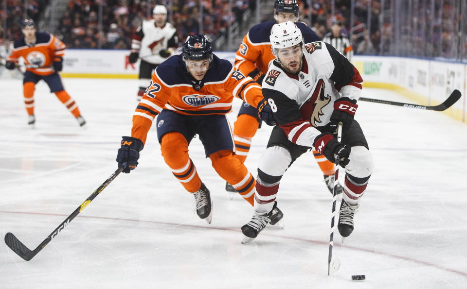 Arizona Coyotes' Nick Schmaltz (8) is chased by Edmonton Oilers' Caleb Jones (82) during first period NHL action in Edmonton, Alberta, on Saturday Jan. 18, 2020. (Jason Franson/The Canadian Press via AP)