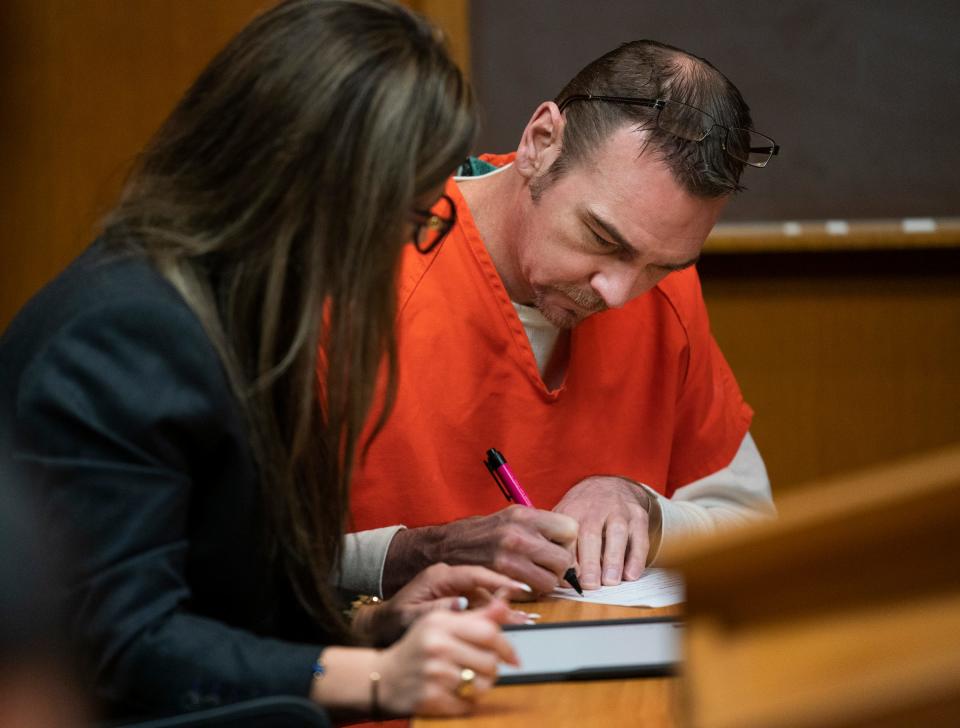 Attorney Mariell Lehman, left, speaks to her client James Crumbley, father of the Oxford High School shooter, as he signs paperwork in the Oakland County Courtroom of Judge Cheryl Matthews on Wednesday, Dec. 13, 2023, for a procedural hearing.