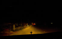 In this Thursday, Nov. 8, 2018, photo, a person drives in the night as a crucifix is seen on the dashboard in Kottayam in the southern Indian state of Kerala. For decades, nuns in India have quietly endured sexual pressure from Catholic priests, an AP investigation has revealed. (AP Photo/Manish Swarup)