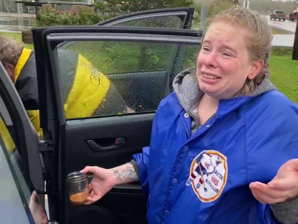 Erika Biggs scooping water out of the vehicle she was able to salvage after the cottage she was staying at flooded. (Aniekan Etuhube/CBC - image credit)