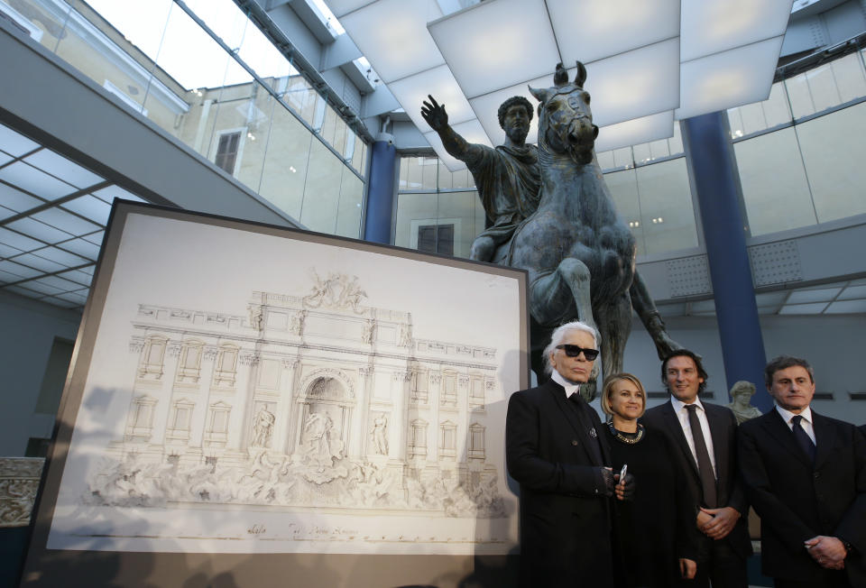 From left, Designer Karl Lagerfeld, Silvia Venturini Fendi, Fendi CEO Pietro Beccari and Rome's Mayor Gianni Alemanno, pose for photographers next to a drawing of the Trevi Fountain, in Rome, Monday, Jan. 28, 2013. The Fendi fashion house is financing an euro 2.12 million ($2.8 million) restoration of Trevi Fountain in Rome, famed as a setting for the film "La Dolce Vita'' and the place where dreamers leave their coins. The 20-month project on one of the city's most iconic fountains was being unveiled at a city hall press conference Monday. (AP Photo/Gregorio Borgia)