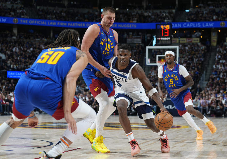 Minnesota Timberwolves guard Anthony Edwards (5) drives past Denver Nuggets center Nikola Jokic (15) as forward Aaron Gordon (50) blocks the lane in the second half of Game 1 of an NBA basketball second-round playoff series Saturday, May 4, 2024, in Denver. (AP Photo/David Zalubowski)