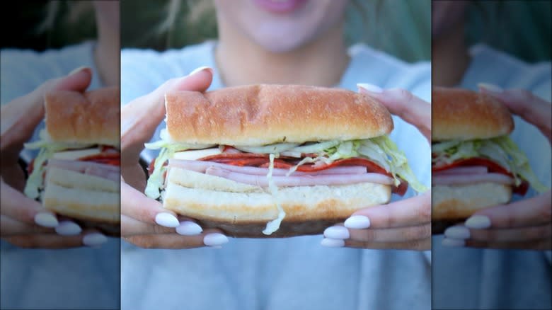 woman holding blimpie sub