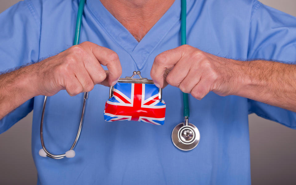 Male nurse wearing blue scrubs - Credit: JOHN GOMEZ / Alamy