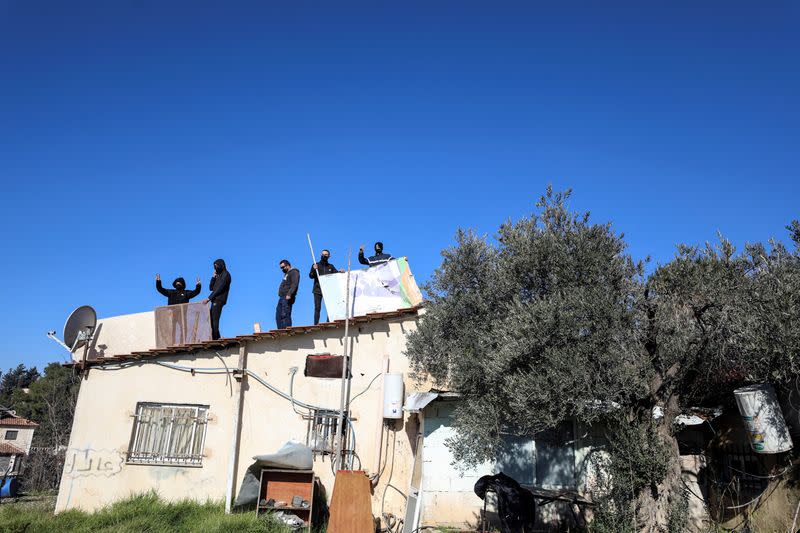 Palestinians take to the roof and threaten to blow-up the building of a home in the flashpoint Sheikh Jarrah neighbourhood of East Jerusalem