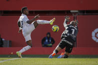 Real Madrid's Vinicius Junior, left, in action against Mallorca's goalkeeper Predrag Rajkovic during a Spanish La Liga soccer match between Mallorca and Real Madrid at the Son Moix stadium in Palma de Mallorca, Spain, Sunday, Feb. 5, 2023. (AP Photo/Francisco Ubilla)