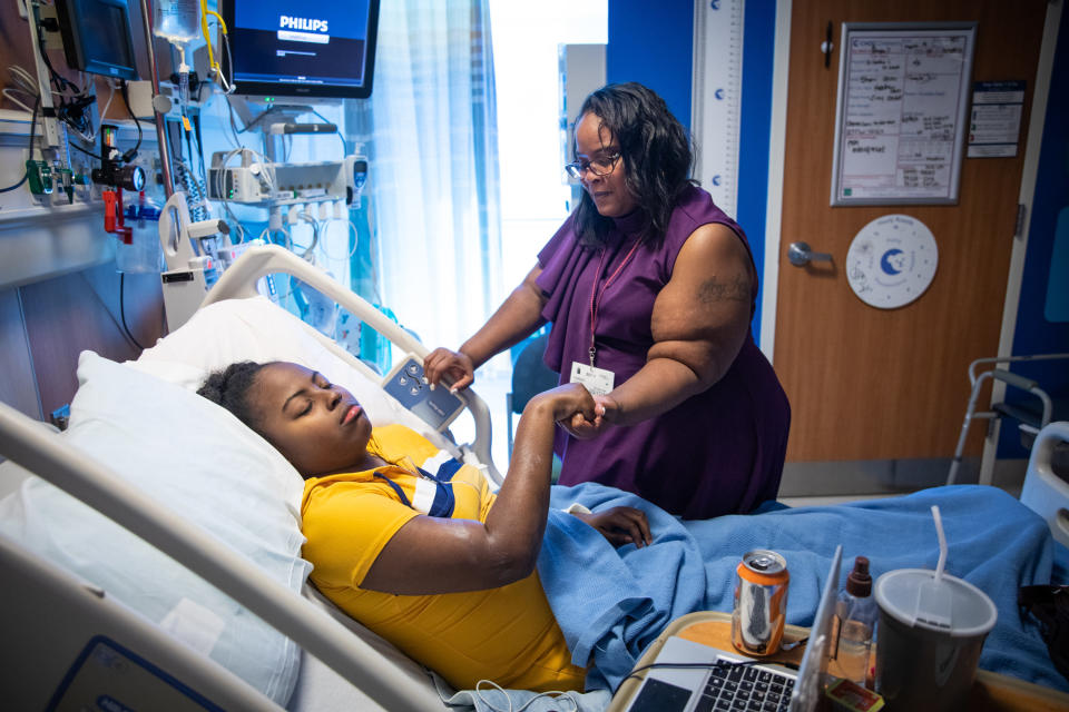 Peoples massages Shayla, who is being treated for sickle cell anemia at Children's Hospital of Orange County, on March 10. (Photo: Tara Pixley for HuffPost)