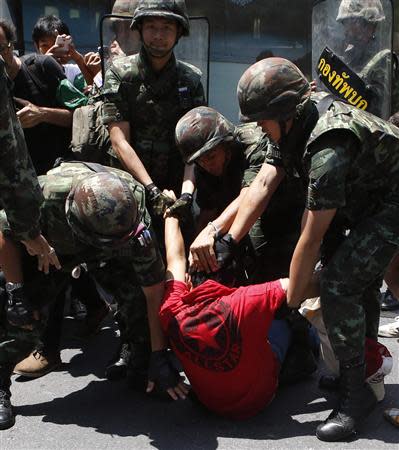 Soldiers detain a protester against military rule during a rally at a shopping district in central Bangkok May 25, 2014. REUTERS/Erik De Castro