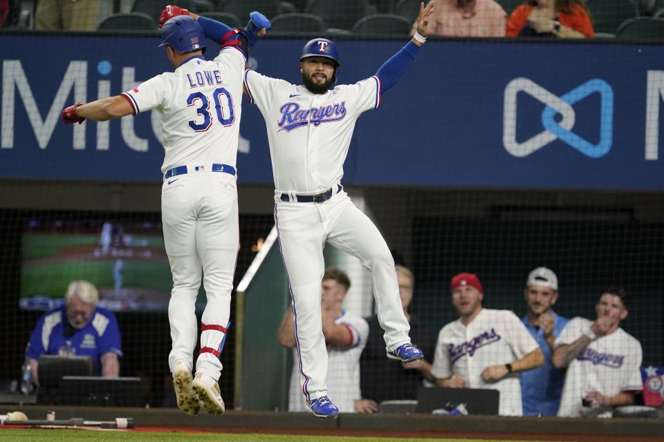 Texas Rangers' Nathaniel Lowe (30) and Isiah Kiner-Falefa, right, celebrate after Lowe hit a two-run home run that scored Kiner-Falefa during the first inning of the team's baseball game against the Houston Astros in Arlington, Texas, Tuesday, Sept. 14, 2021. (AP Photo/Tony Gutierrez)
