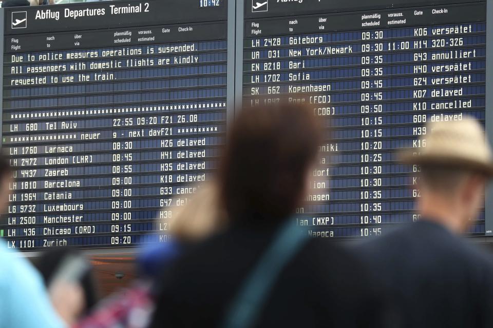 People wait inside the Munich Airport in Munich, Germany, Tuesday, Aug. 27, 2019. Munich Airport says it has closed some of its terminals because a person has likely entered the "clean area" through an emergency exit door. The international airport tweeted Tuesday morning that terminal 2 and areas B and C or terminal 1 had been closed for police operations.(AP Photo/Matthias Schrader)