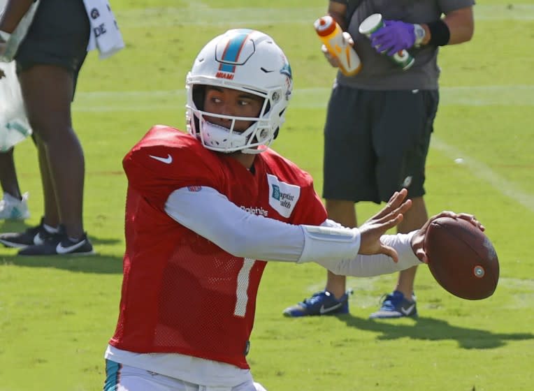 FILE - In this Aug. 18, 2020, file photo, Miami Dolphins quarterback Tua Tagovailoa (1) throws the ball during an NFL football training camp practice in Davie, Fla. If Brian Flores is to become the Miami Dolphins' first Super Bowl coach since Don Shula, he needs for Tua Tagovailoa to become their best quarterback since Dan Marino.(AP Photo/Joel Auerbach, File)