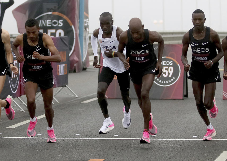 In this Oct. 12, 2019 photo, marathon runner Eliud Kipchoge from Kenya, white vest, wearing Nike AlphaFly prototype running shoe, and his first pacemaking team, wearing pink Nike Vaporfly shoes, leave the start line on Reichsbrucke during the INEOS 1:59 Challenge attempt to run a sub two-hour marathon in Vienna, Austria. Nike has a new racing shoe; The Air Zoom Alphafly Next%, which was unveiled at a flashy fashion show in New York on Wednesday night, Feb. 5, 2020. Kipchoge wore a prototype of the shoe when he ran the world's first sub-2-hour marathon in an unofficial race in Octob(AP Photo/Ronald Zak, File)