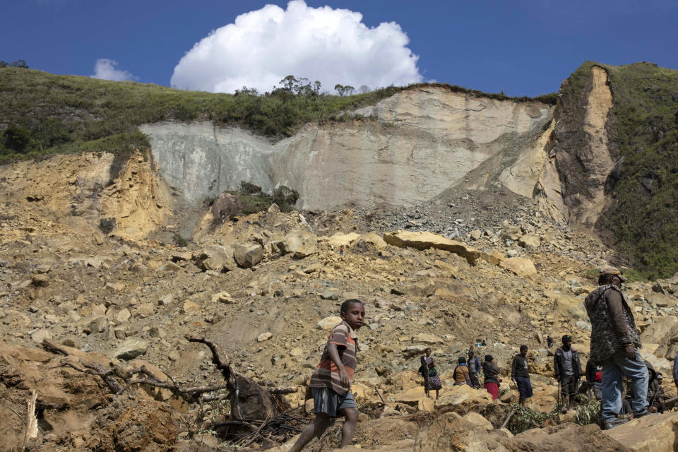 In this photo released by UNDP Papua New Guinea, villagers search through a landslide in Yambali village, in the Highlands of Papua New Guinea, Monday, May 27, 2024. Authorities fear a second landslide and a disease outbreak are looming at the scene of Papua New Guinea's recent mass-casualty disaster because of water streams trapped beneath tons of debris and decaying corpses seeping downhill following the May 24 landslide. (Juho Valta/UNDP Papua New Guinea via AP)