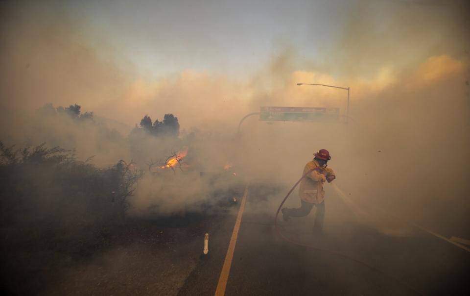 Firefighter Vince Valdivia is surrounded by heavy smoke as he battles the advancing Silverado fire in Irvine.