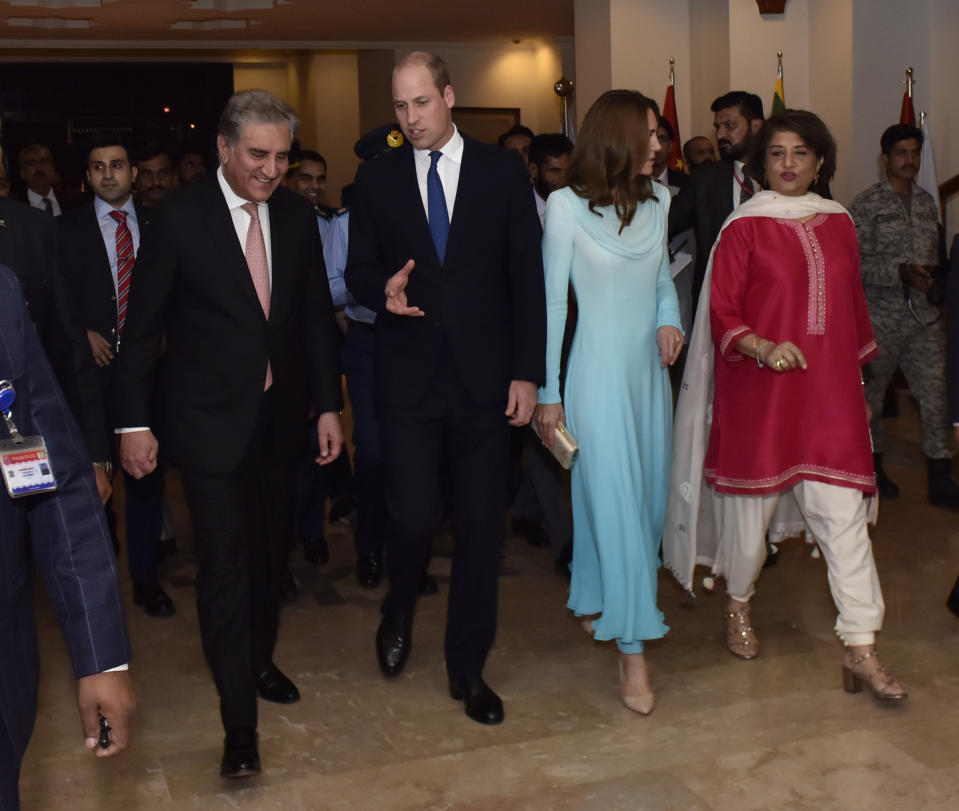 In this picture released by the Foreign Office, Pakistan's Foreign Minister Shah Mahmood Qureshi, left, escorts Britain's Prince William and his wife Kate as they arrive at the Nur Khan base in Islamabad, Pakistan, Monday, Oct. 14, 2019. They are on a five-day visit, which authorities say will help further improve relations between the two countries. (Pakistan Foreign Office via AP)