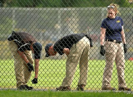 FBI technicians examine the outfield area of a baseball field for evidence where shots were fired during a Congressional baseball practice wounding House Majority Whip Steve Scalise (R-LA), in Alexandria, Virginia, U.S., June 14, 2017. REUTERS/Mike Theiler