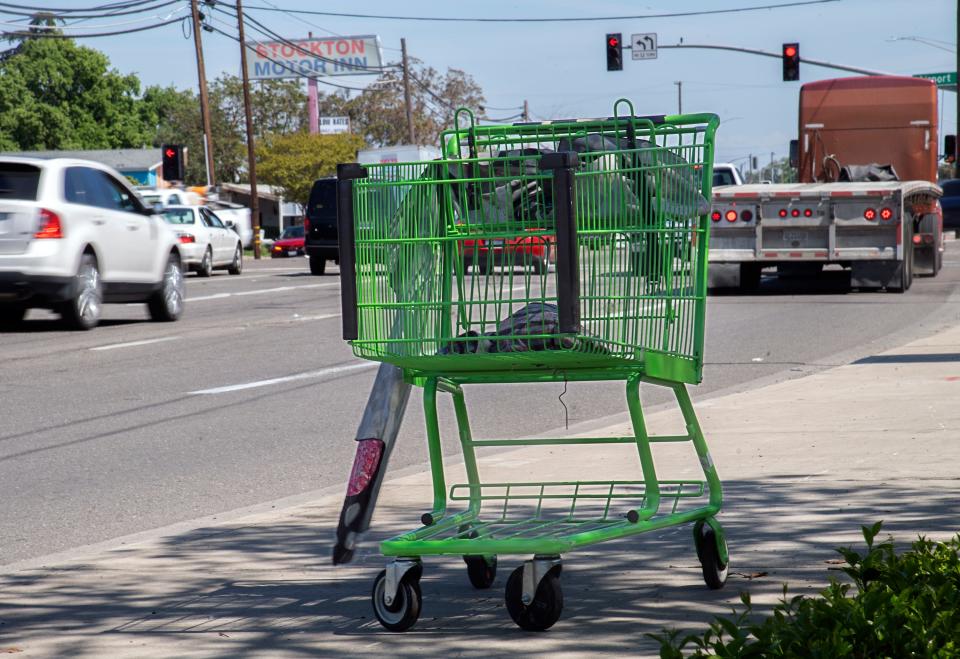 An abandoned shopping cart sits on the sidewalk on Dr. Martin Luther King Jr. Boulevard near Airport Way in Stockton Apr. 3, 2024.